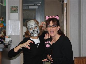 Two teachers posing one wearing a skeleton mask