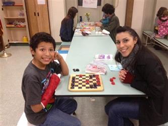 Student sitting at a table with a board game