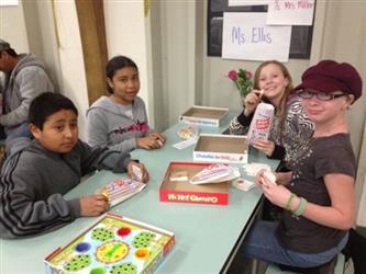 Students playing board games and smiling at the camera
