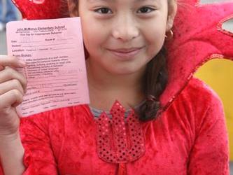 A student holding up a pink piece of paper