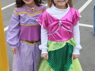 Two students wearing costumes and smiling