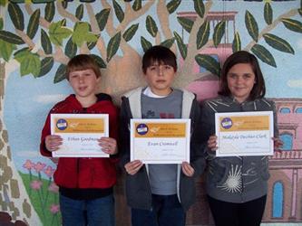 Students in front of a tree painting holding up certificates