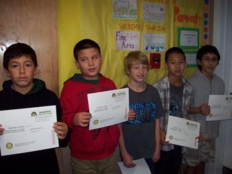 Students holding up paper certificates