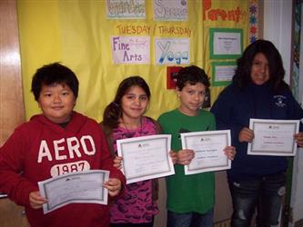 Four students holding up certificates